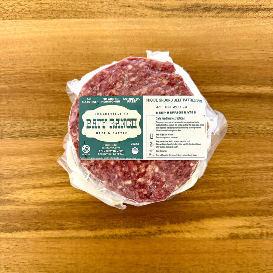 Packaged ground beef patties with a label on a wooden surface
