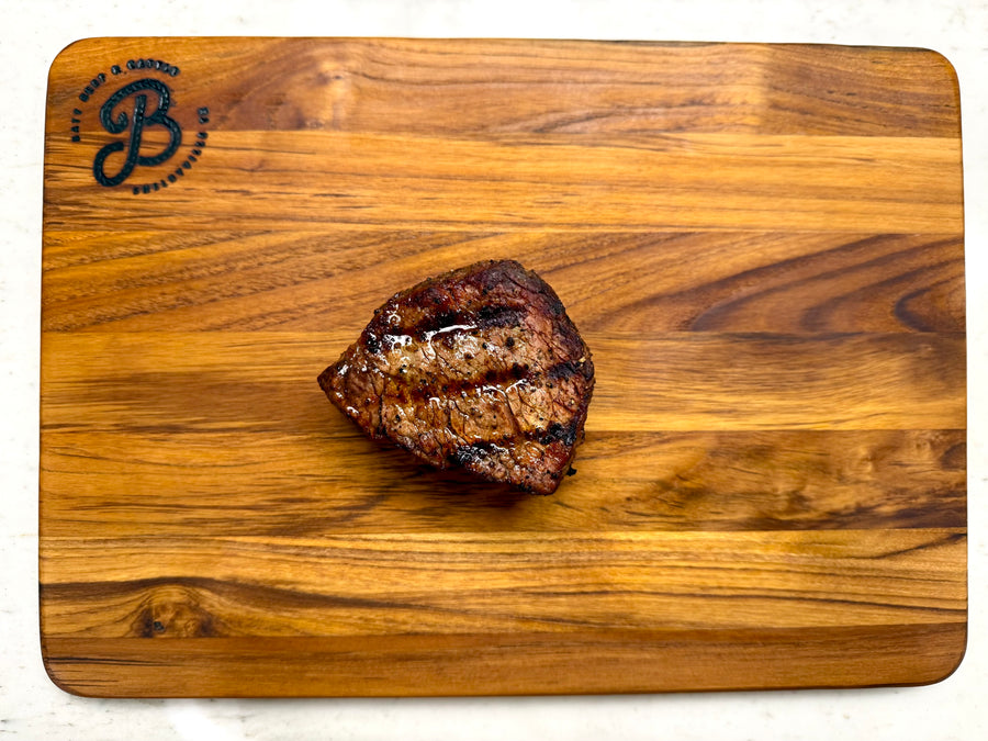 cooked filet steak on wooden cutting board