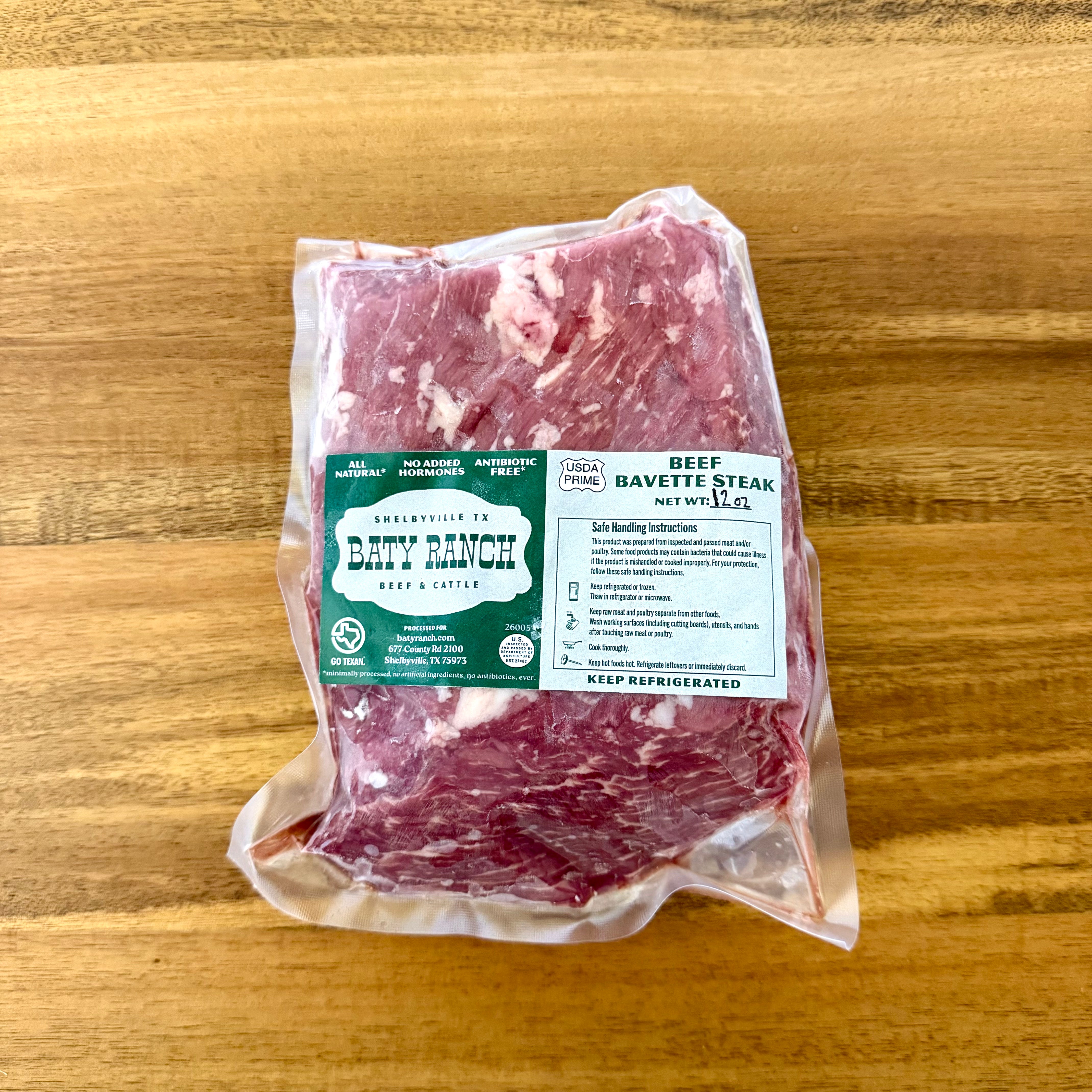 Packaged beef bavette steak on a wooden surface with a Baty Ranch label.