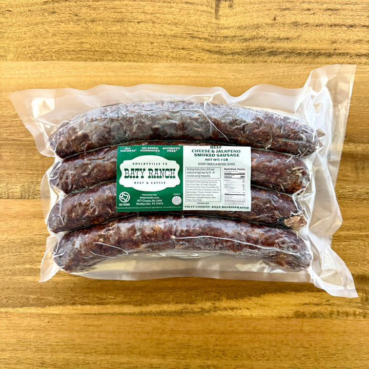 Packaged jalapeno & cheese sausages with a label on a wooden surface