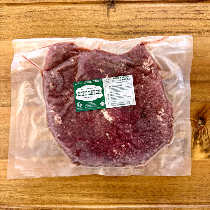 Packaged beef steak with a label on a wooden surface