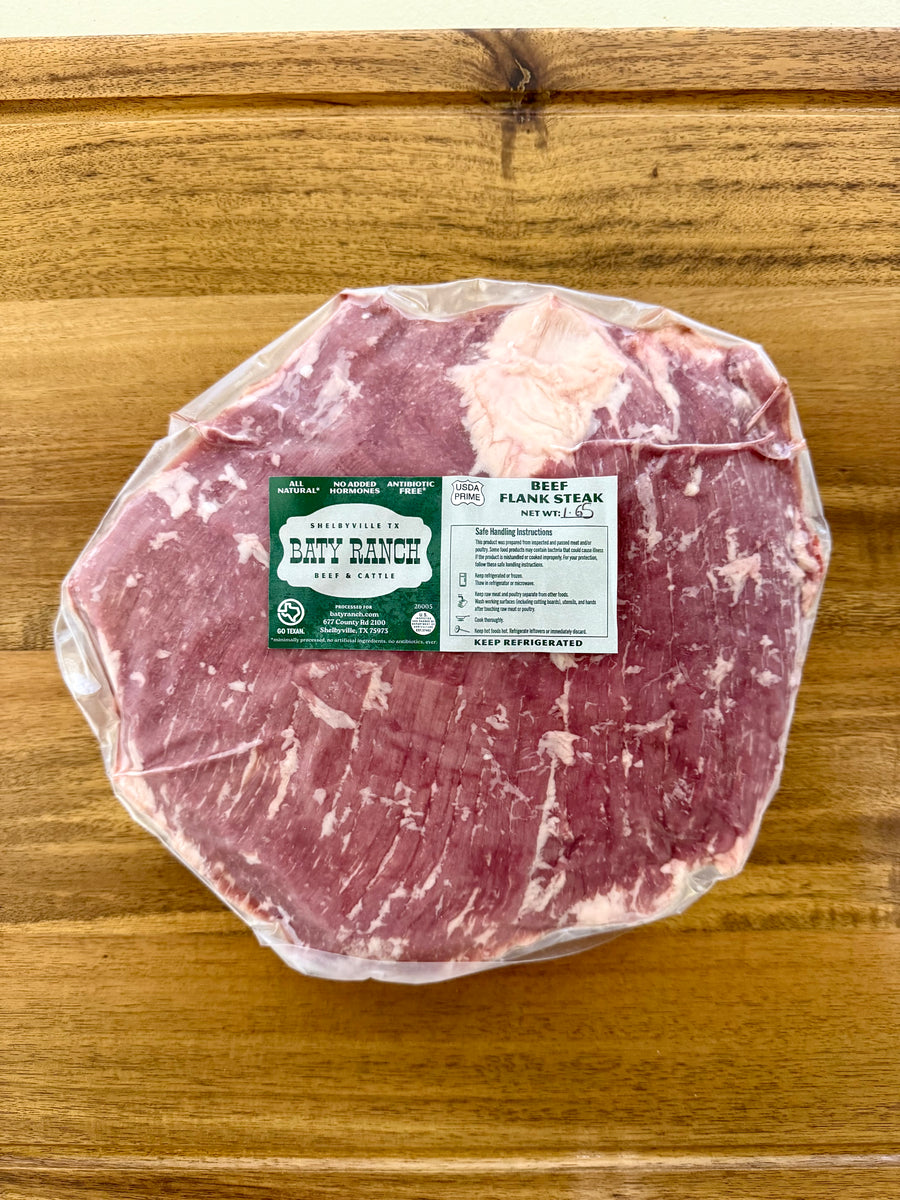 Packaged raw meat on a wooden surface with a label