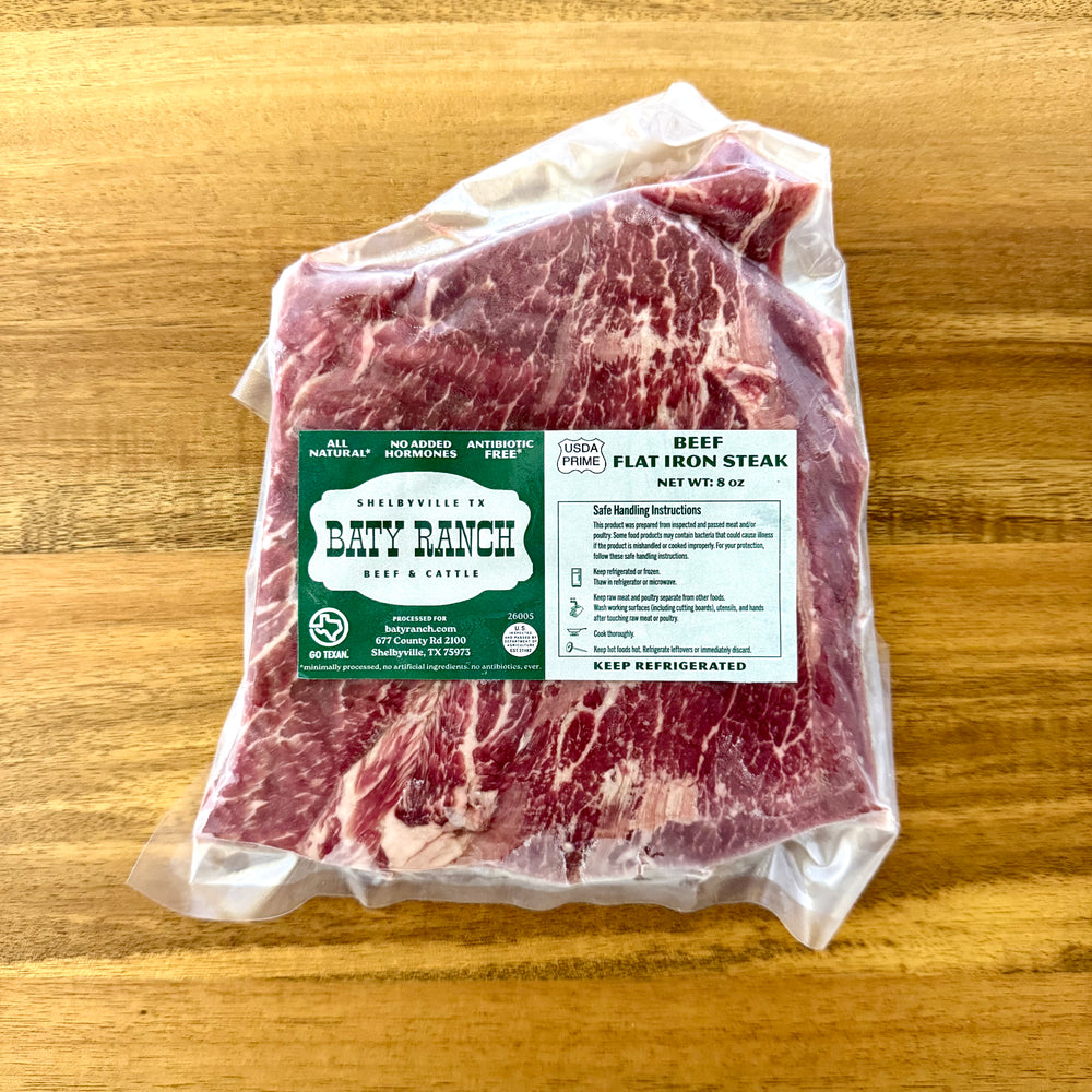 Packaged beef flat iron steak with Baty Ranch labels on a wooden surface