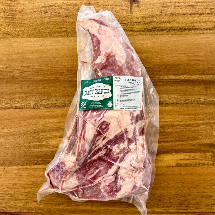 Raw beef tri-tip package with a label on a wooden surface