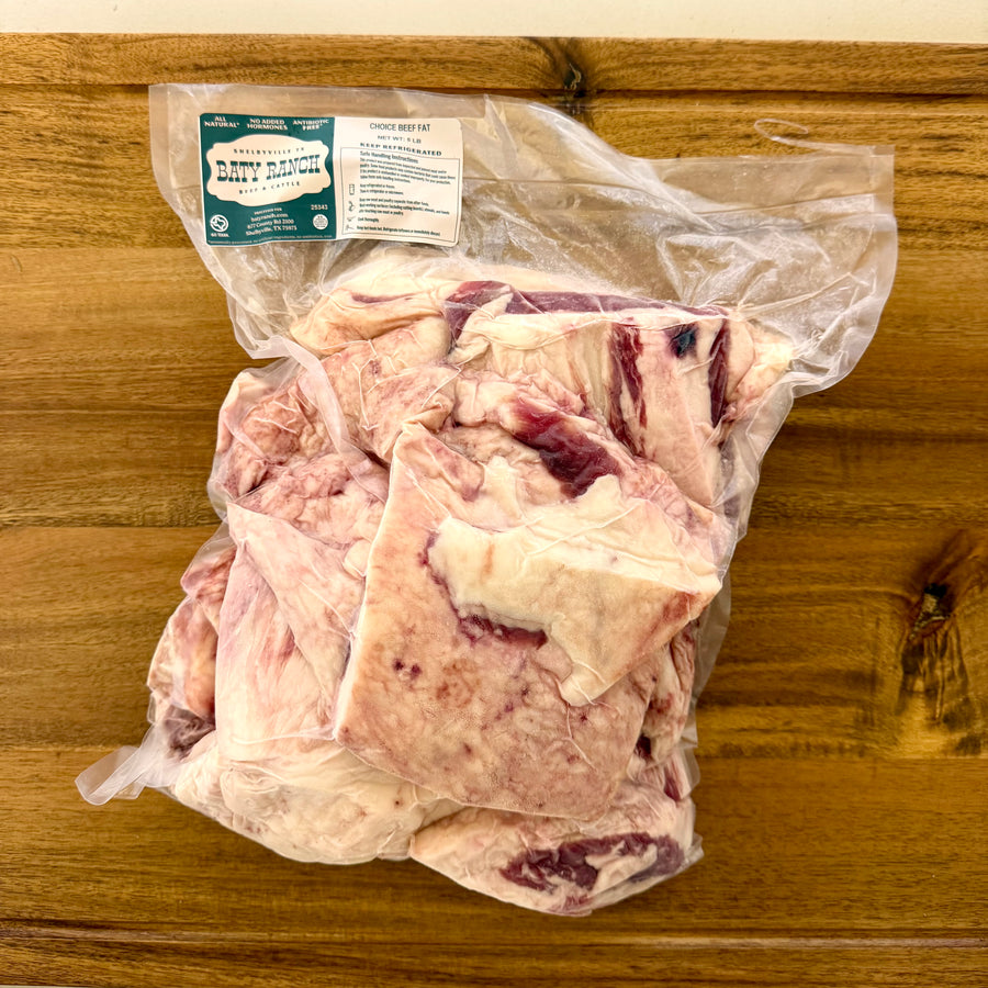 Bag of raw meat on a wooden surface with a visible label.