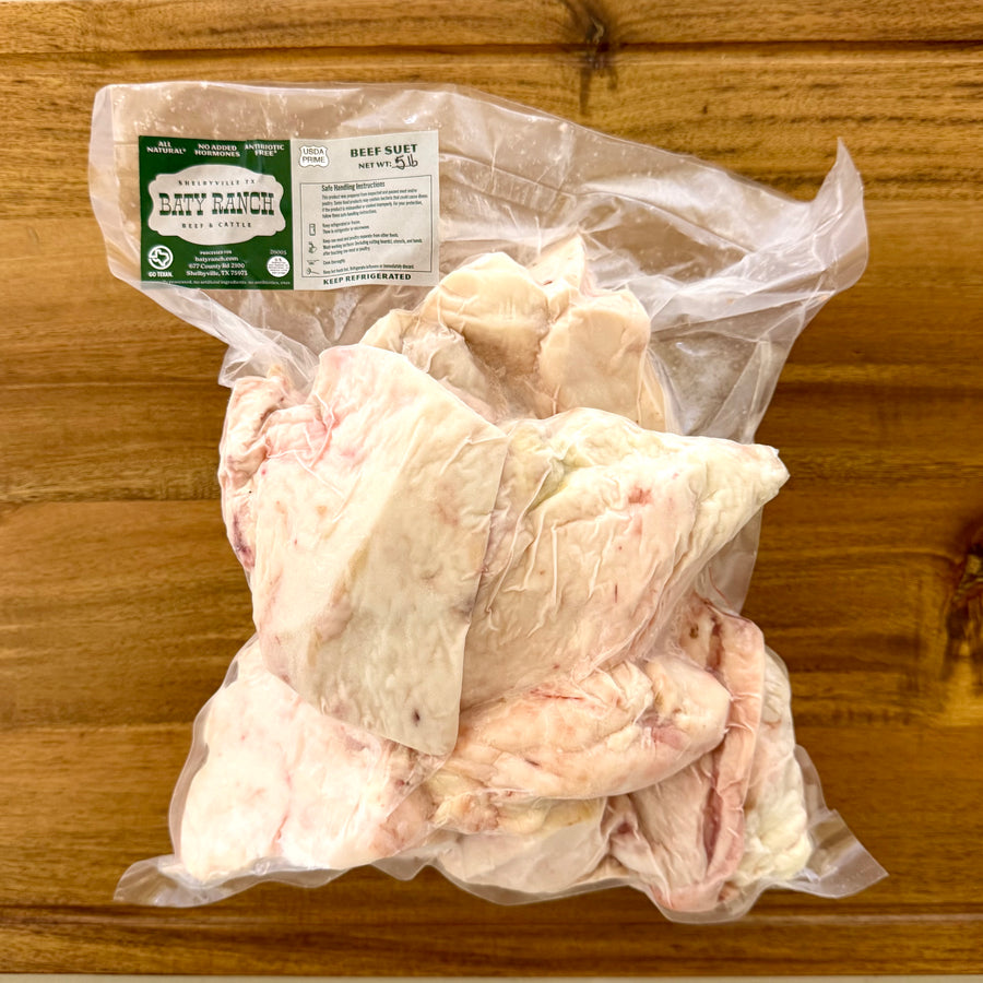 pure beef suet in a vacuum package with a label on a wooden surface