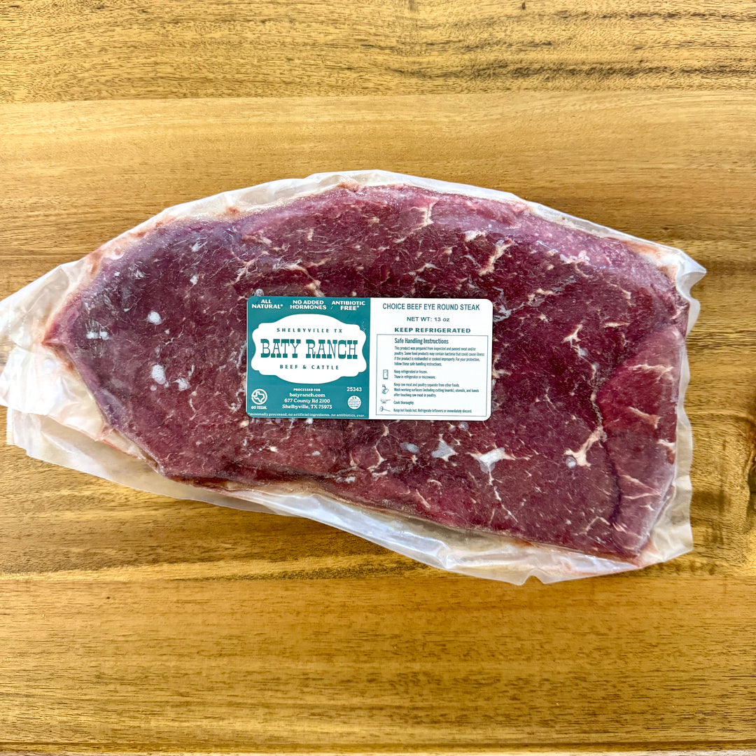 Raw beef steak with a label on a wooden surface